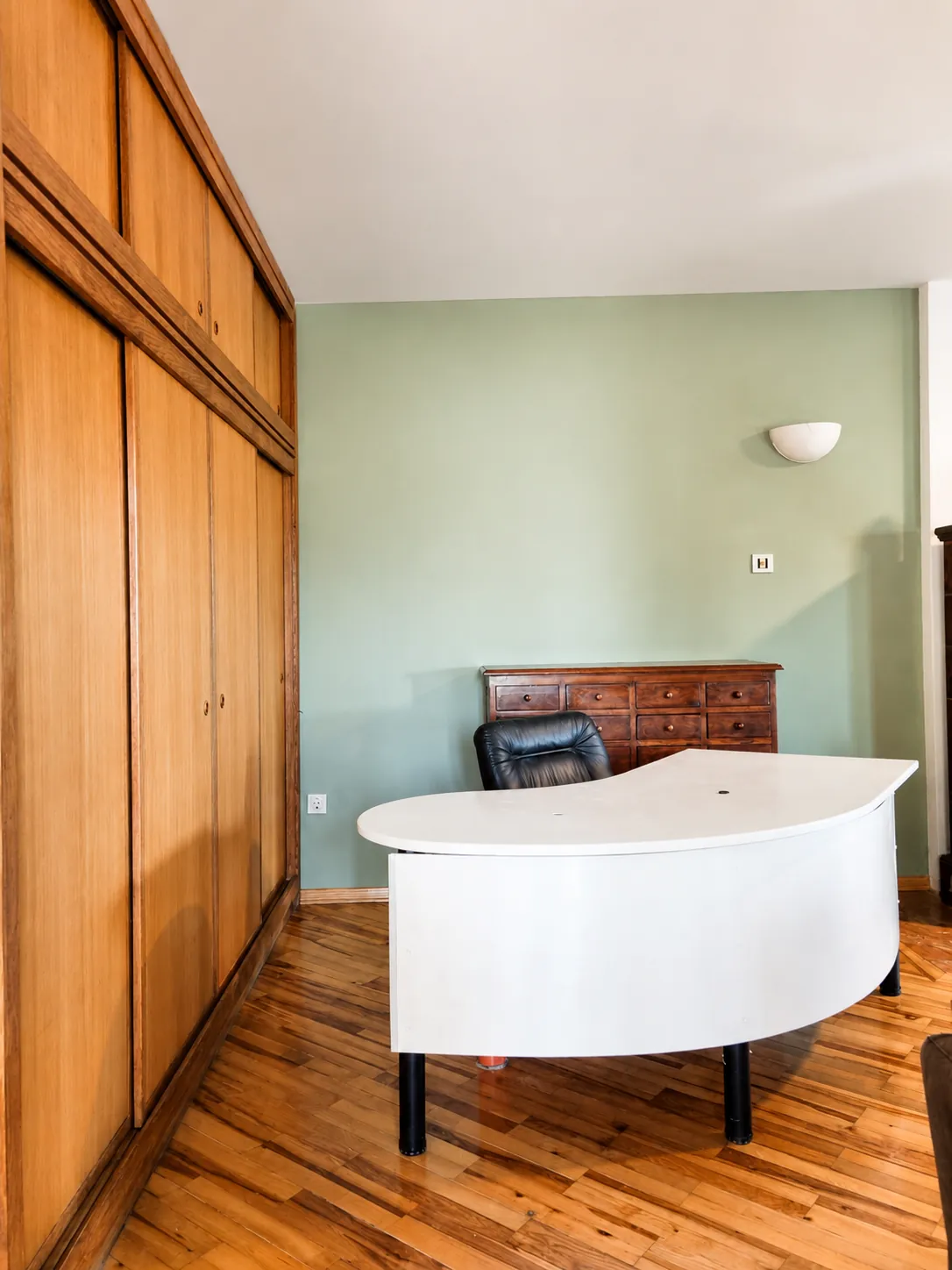 A separate room set up as a home office, with a desk and chair